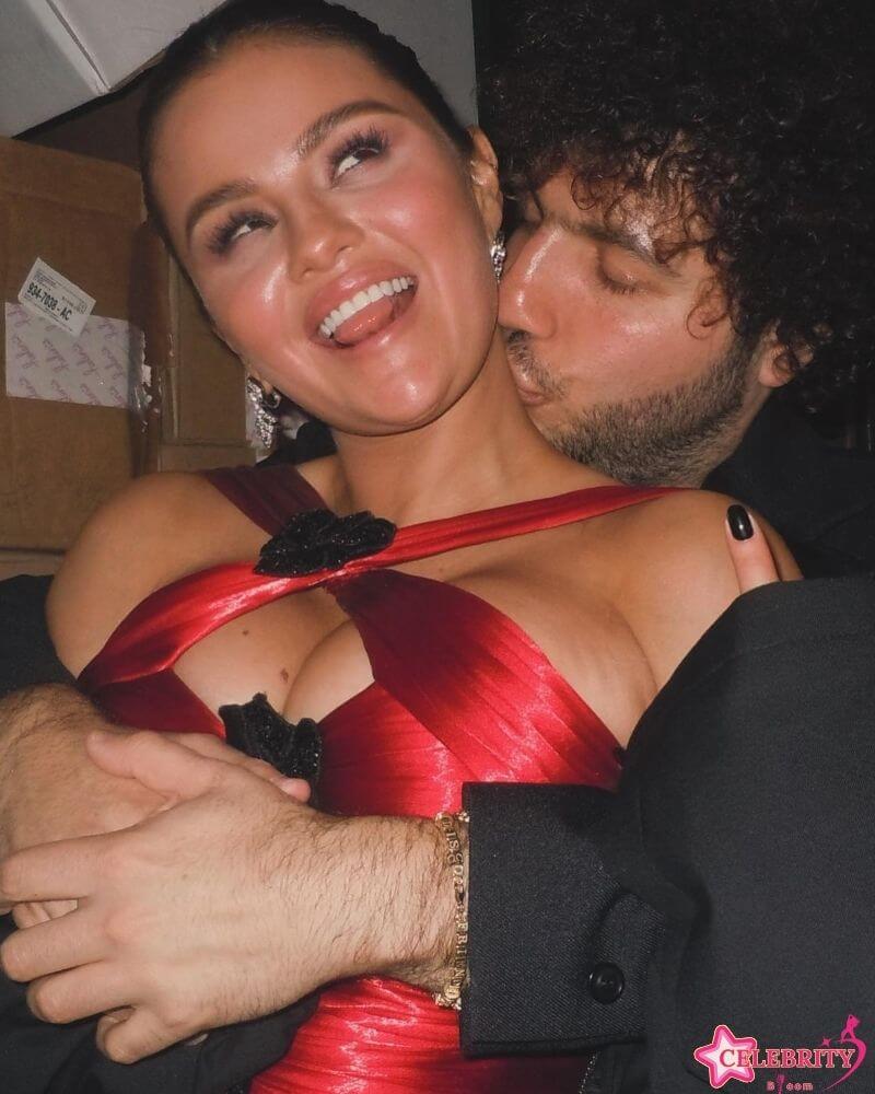 Selena Gomez and her boyfriend, Benny Blanco, sharing a tender kiss during a romantic moment at a public event.